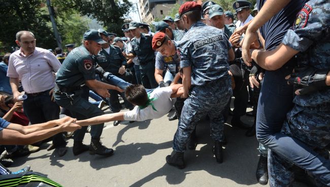 Сотрудники полиции задерживают участника акции протеста против повышения тарифов на электроэнергию в Ереване
