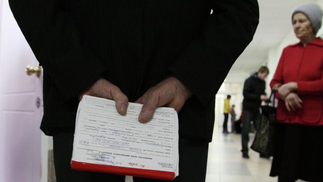 Пожилой мужчина держит в руках медицинскую карточку Пожилой мужчина держит в руках медицинскую карточку