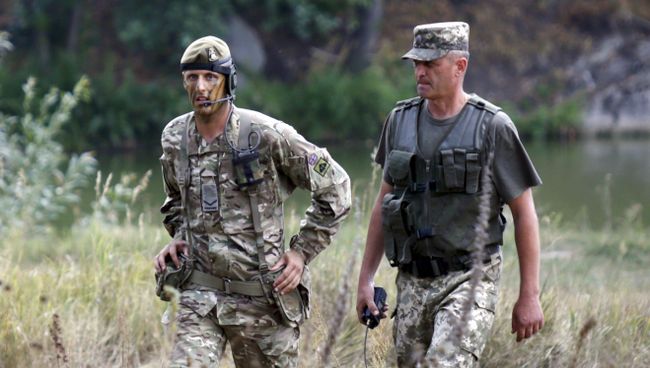 Британский военный инструктор и украинский офицер во время учений на полигоне возле Житомира, Украина Британский военный инструктор и украинский офицер во время учений на полигоне возле Житомира, Украина