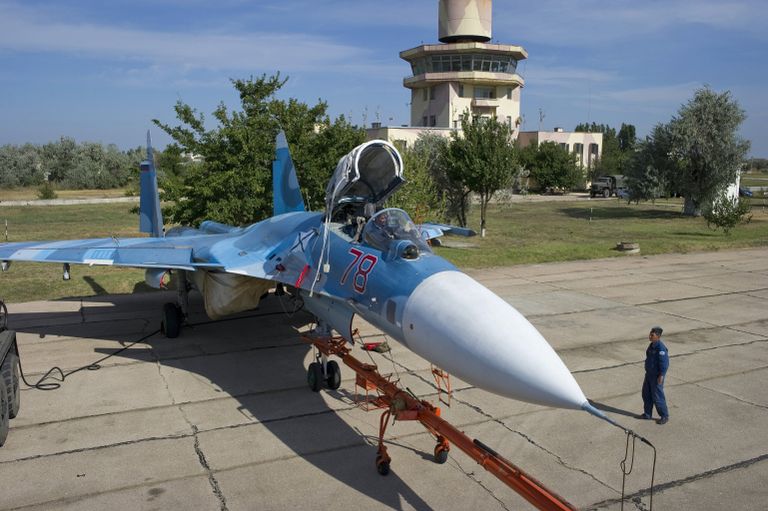 Военнослужащие подготавливают самолет СУ-33 к тренировочным полетам летчиков палубной авиации Военнослужащие подготавливают самолет СУ-33 к тренировочным полетам летчиков палубной авиации