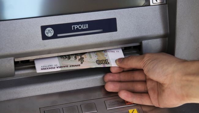 Горожанин обналичивает денежные средства в банкомате Донецка Горожанин обналичивает денежные средства в банкомате Донецка