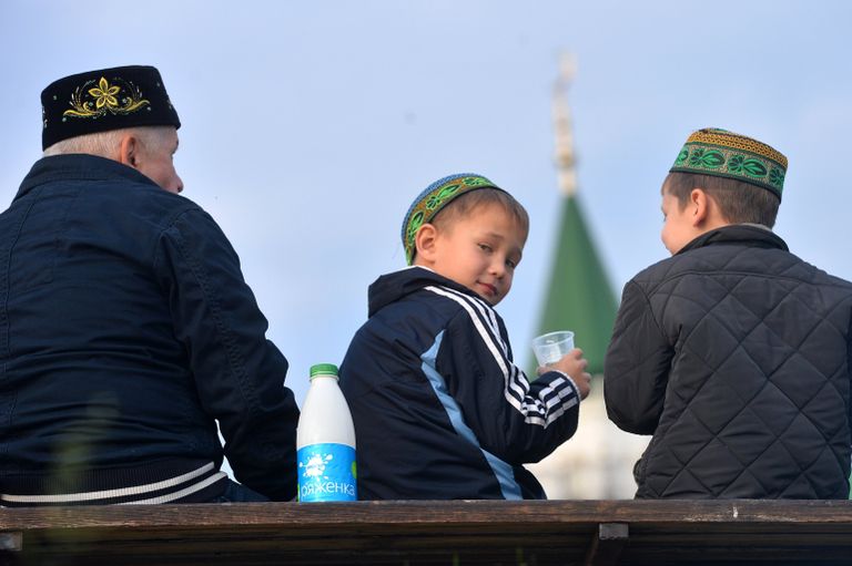 Мужчина с детьми после намаза на берегу озера Кабан у мечети Аль-Марджани в день празднования Курбан-Байрама в Казани Мужчина с детьми после намаза на берегу озера Кабан у мечети Аль-Марджани в день празднования Курбан-Байрама в Казани