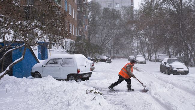 Сотрудник коммунальных служб убирает заснеженные улицы города Омска Сотрудник коммунальных служб убирает заснеженные улицы города Омска