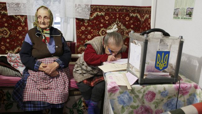 Женщины заполняют избирательные бюллетени во время выборов в поселке Сартана Донецкой области, Украина Женщины заполняют избирательные бюллетени во время выборов в поселке Сартана Донецкой области, Украина