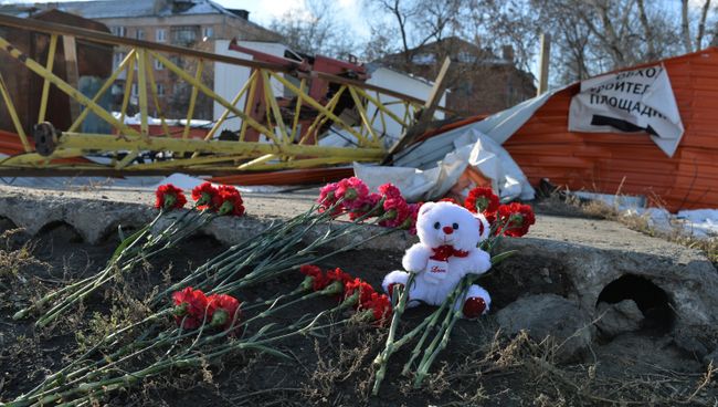 Цветы на месте падения башенного крана в Омске, в результате которого погибли четыре человека