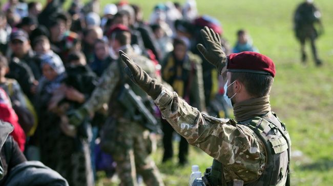 Словенский военный управляет движением беженцев, прибывших из Хорватии. Архивное фото Словенский военный управляет движением беженцев, прибывших из Хорватии. Архивное фото