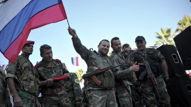 Сирийские военные с российским флагом во время митинга в городе Тартус, Сирия Сирийские военные с российским флагом во время митинга в городе Тартус, Сирия