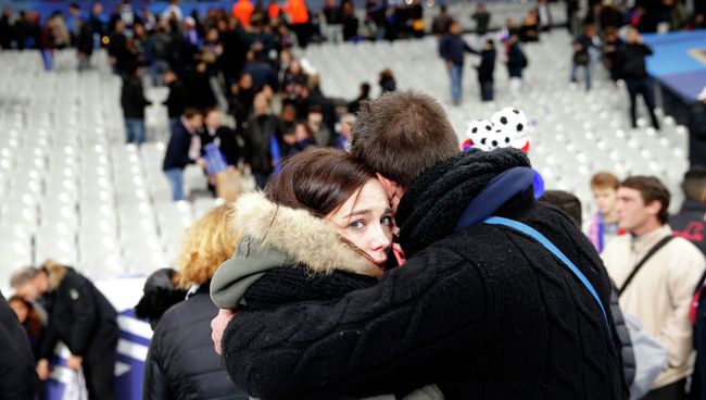 Люди во время эвакуации со стадиона Stade de France, рядом с которым прогремели взрывы