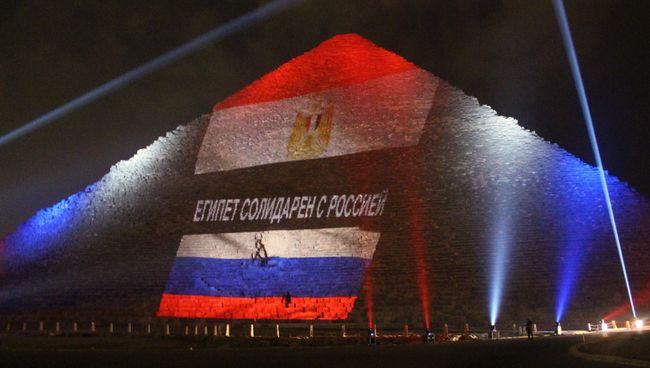 Древнеегипетская пирамида Хеопса на плато Гиза в Каире, подсвеченная цветами российского и египетского флагов во время акции памяти жертв. Архивное фото