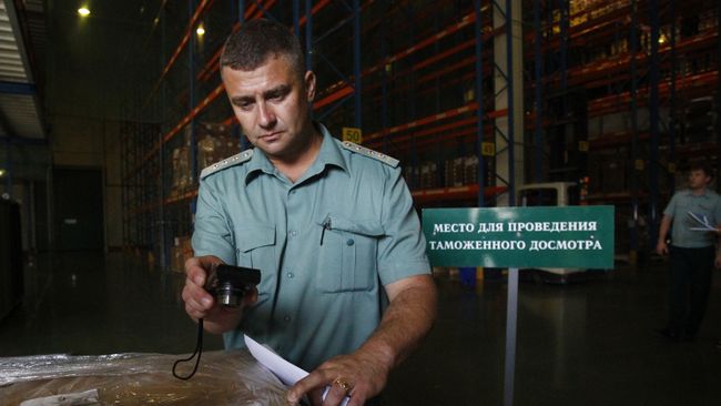 Сотрудник Федеральной таможенной службы досматривает груз. Архивное фото Сотрудник Федеральной таможенной службы досматривает груз. Архивное фото