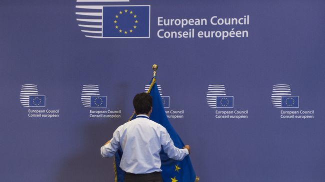 Служащий поправляет флаг в здании Совета Европы в Брюсселе, Бельгия. Архивное фото Служащий поправляет флаг в здании Совета Европы в Брюсселе, Бельгия. Архивное фото