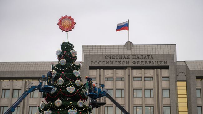 Рабочие украшают новогоднюю елку, установленную у Счётной Палаты РФ