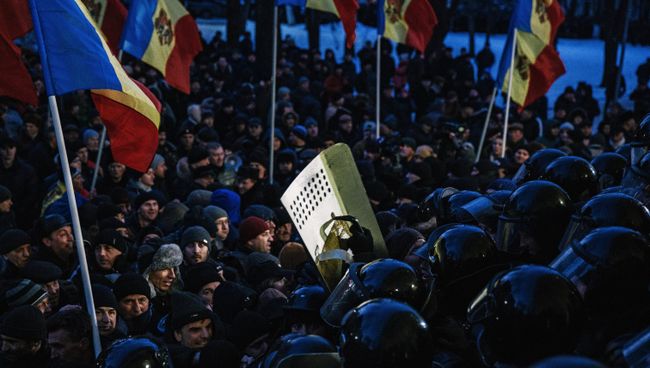 Протестующие и сотрудники правоохранительных органов у здания парламента в Кишиневе