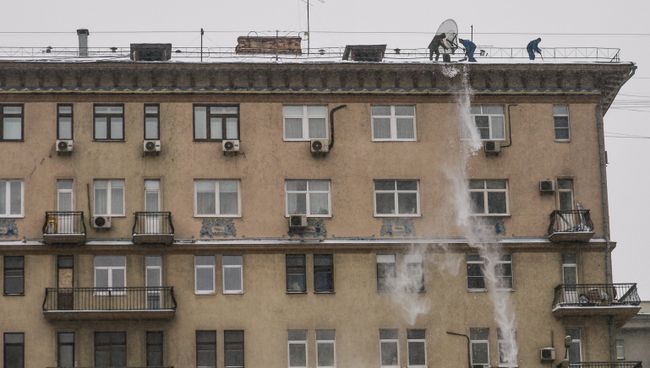 Работники служб ЖКХ сбрасывают снег с крыши одного из домов на Смоленском бульваре в Москве Работники служб ЖКХ сбрасывают снег с крыши одного из домов на Смоленском бульваре в Москве