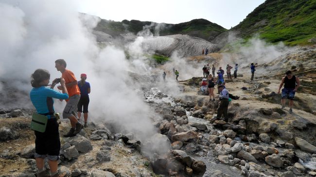 Туристы осматривают долину гейзеров на одном из склонов Мутновского вулкана