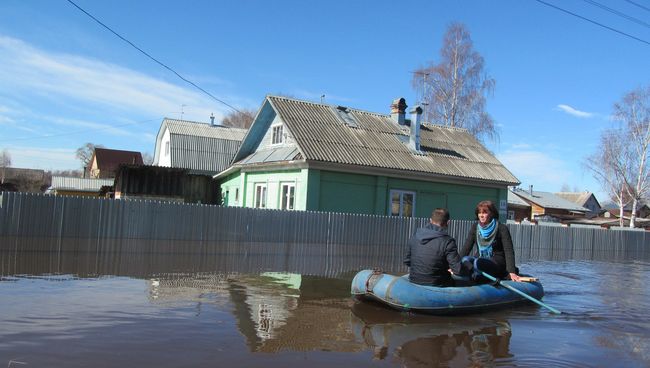 Люди на резиновой лодке во время паводка в Великом Устюге Люди на резиновой лодке во время паводка в Великом Устюге