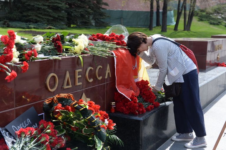 Женщина возлагает цветы к тумбе города Одессы у мемориала Могила Неизвестного Солдата в Александровском саду в Москве Женщина возлагает цветы к тумбе города Одессы у мемориала Могила Неизвестного Солдата в Александровском саду в Москве