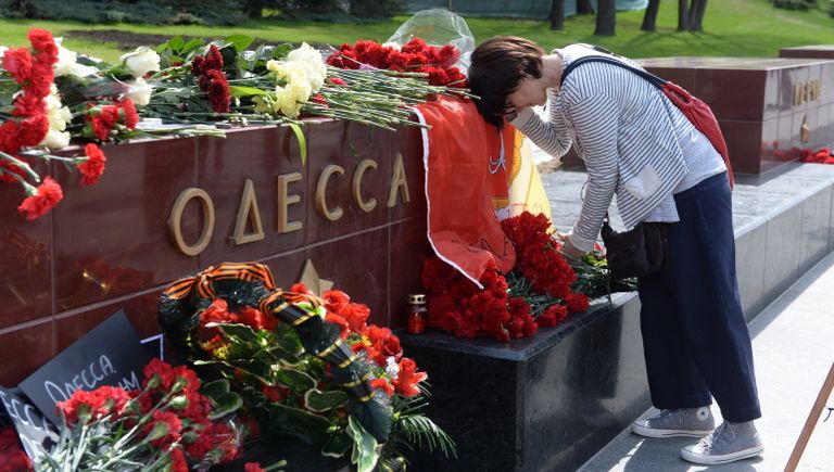 Женщина возлагает цветы к тумбе города Одессы у мемориала Могила Неизвестного Солдата в Александровском саду в Москве Женщина возлагает цветы к тумбе города Одессы у мемориала Могила Неизвестного Солдата в Александровском саду в Москве