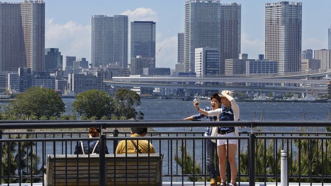 Пара делает селфи в районе Одайба, Япония. Архивное фото Пара делает селфи в районе Одайба, Япония. Архивное фото
