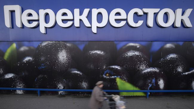Женщина везет тележку с продуктами у супермаркета торговой сети Перекресток на Славянском бульваре в Москве