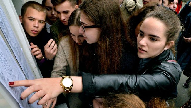 Ученики ищут свои фамилии в списках на сдачу единого государственного экзамена по русскому языку в средней общеобразовательной школе №13 города Владивостока