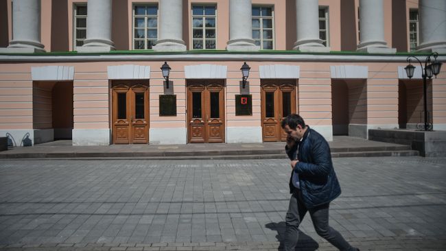 Прохожий у здания Московской городской Думы на Страстном бульваре в Москве Прохожий у здания Московской городской Думы на Страстном бульваре в Москве