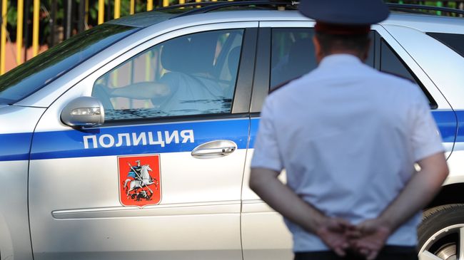 Полицейский автомобиль и сотрудник полиции в Москве. Архивное фото Полицейский автомобиль и сотрудник полиции в Москве. Архивное фото