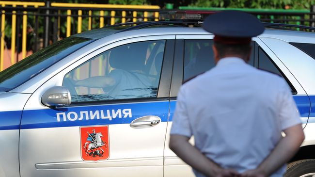 Полицейский автомобиль и сотрудник полиции. Архивное фото Полицейский автомобиль и сотрудник полиции. Архивное фото