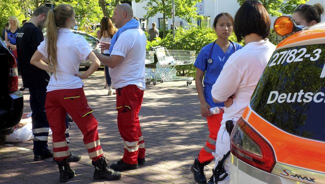 Медработники у здания кинотеатра в немецком Фирнхайме, где произошла стрельба