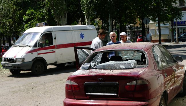 Мужчины у автомобиля, пострадавшего в результате взрыва на территории республиканского травматологического центра в Донецке Мужчины у автомобиля, пострадавшего в результате взрыва на территории республиканского травматологического центра в Донецке