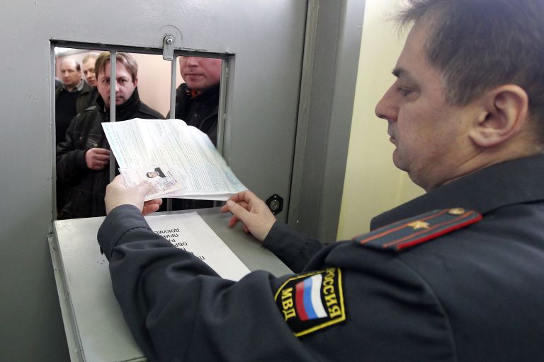 Инспектор ГИБДД принимает документы от водителя на одном из московских пунктов техосмотра автомобилей Инспектор ГИБДД принимает документы от водителя на одном из московских пунктов техосмотра автомобилей