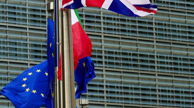 Флаги Великобритании и Евросоюза у главного здания Европарламента в Брюсселе. Архивное фото Флаги Великобритании и Евросоюза у главного здания Европарламента в Брюсселе. Архивное фото
