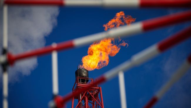 Газовый факел морской нефтеперерабатывающей платформы. Архивное фото Газовый факел морской нефтеперерабатывающей платформы. Архивное фото