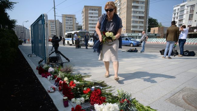 Женщина возлагает цветы у посольства Франции в Москве в память о погибших в результате террористических акта в Ницце