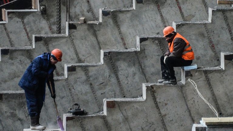 Рабочие на строительной площадке Большой спортивной арены Лужники в Москве Рабочие на строительной площадке Большой спортивной арены Лужники в Москве