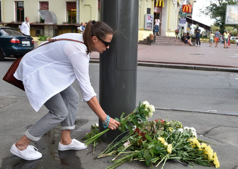 Женщина возлагает цветы к месту гибели журналиста Павла Шеремета Женщина возлагает цветы к месту гибели журналиста Павла Шеремета
