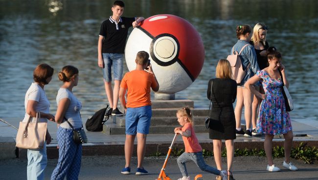 Прохожие рядом с гигантским покеболом из компьютерной игры Pokemon Go от компании Nintendo на набережной городского пруда в Екатеринбуре. Архивное фото Прохожие рядом с гигантским покеболом из компьютерной игры Pokemon Go от компании Nintendo на набережной городского пруда в Екатеринбуре. Архивное фото
