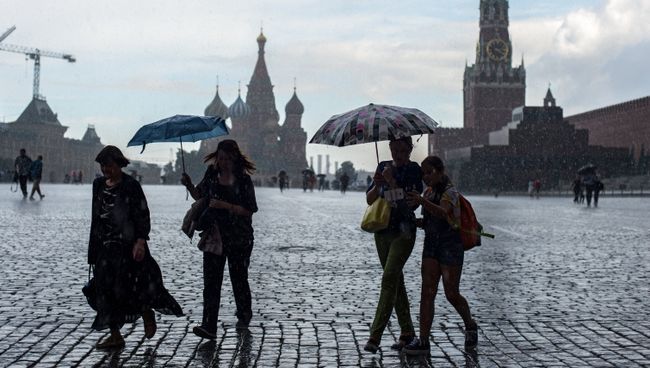 Горожане во время дождя на Красной площади в Москве Горожане во время дождя на Красной площади в Москве