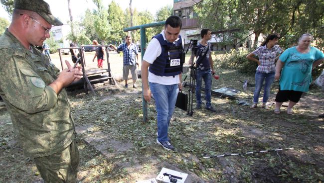 Представители Специальной мониторинговой миссии (СММ) ОБСЕ осматривают воронку от снаряда во время фиксации разрушений в Ясиноватой в Донбассе в результате обстрела города со стороны украинских силовиков Представители Специальной мониторинговой миссии (СММ) ОБСЕ осматривают воронку от снаряда во время фиксации разрушений в Ясиноватой в Донбассе в результате обстрела города со стороны украинских силовиков