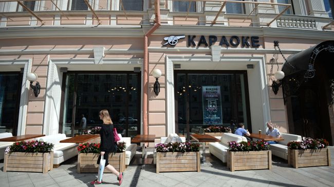 Прохожая у летней веранды на реконструированной Тверской улице в Москве. Архивное фото Прохожая у летней веранды на реконструированной Тверской улице в Москве. Архивное фото