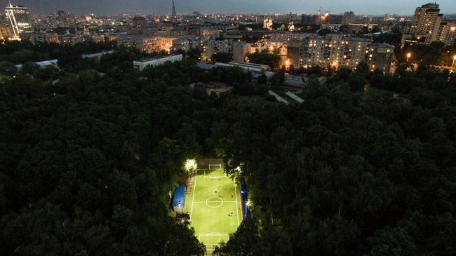 Люди играют в футбол в Нескучном саду в Москве Люди играют в футбол в Нескучном саду в Москве
