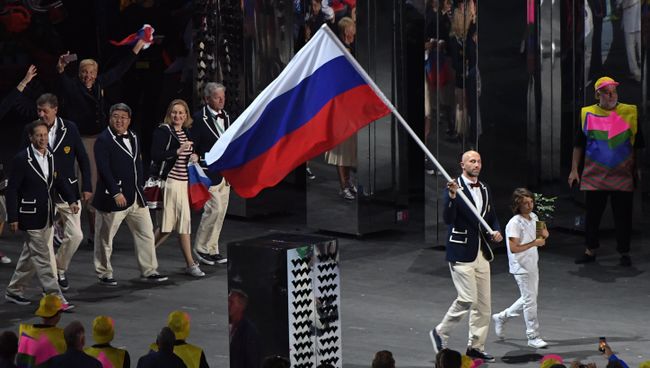 Знаменосец сборной России Сергей Тетюхин несет российский флаг на церемонии открытия летних Олимпийских игр в Рио