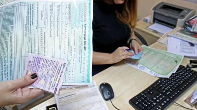 Оформление полиса ОСАГО в страховой компании. Архивное фото
