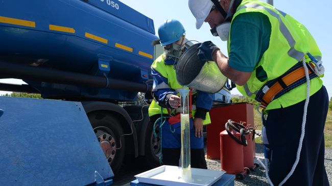 Сотрудники АЗС берут пробу бензина во время приемки бензовоза Сотрудники АЗС берут пробу бензина во время приемки бензовоза