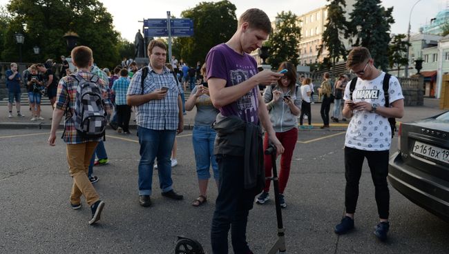 Молодые люди играют в Pokemon Go от компании Nintendo на экране мобильного телефона в Ильинском сквере в Москве. Архивное фото Молодые люди играют в Pokemon Go от компании Nintendo на экране мобильного телефона в Ильинском сквере в Москве. Архивное фото