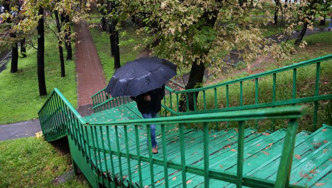 Прохожий во время дождя. Архивное фото
