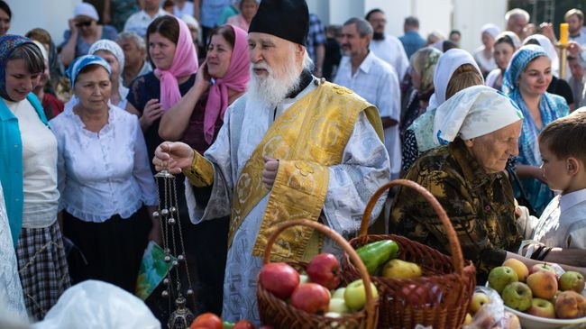Священнослужитель и верующие во время богослужения в честь праздника Преображения Господня у собора Воздвижения Креста Господня в Омске Священнослужитель и верующие во время богослужения в честь праздника Преображения Господня у собора Воздвижения Креста Господня в Омске