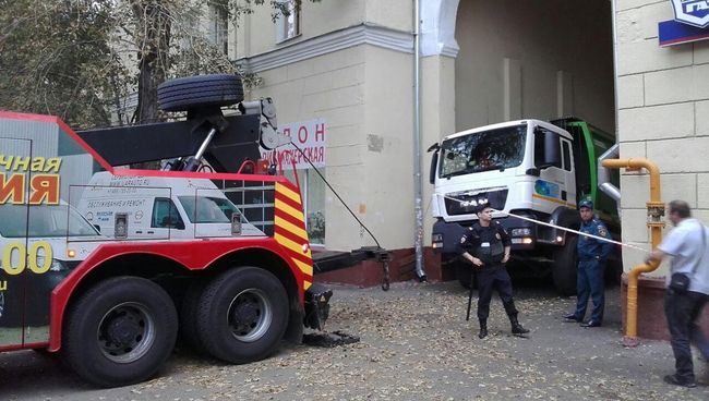 В Москве мусоровоз угодил в яму после провала грунта В Москве мусоровоз угодил в яму после провала грунта