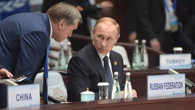 Владимир Путин и помощник президента Юрий Ушаков во время первого рабочего заседания глав делегаций государств-участников Группы двадцати Владимир Путин и помощник президента Юрий Ушаков во время первого рабочего заседания глав делегаций государств-участников Группы двадцати
