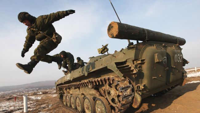 Военнослужащие экипажа БМП покидают машину после стрельбы во время учений мотострелковой бригады на полигоне в Приморском крае